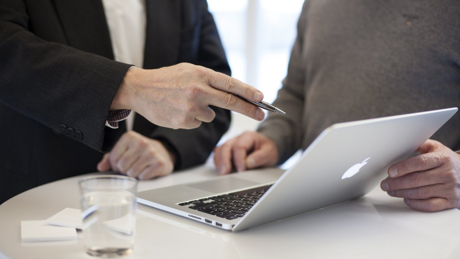 Two professionals discussing IT options on a laptop