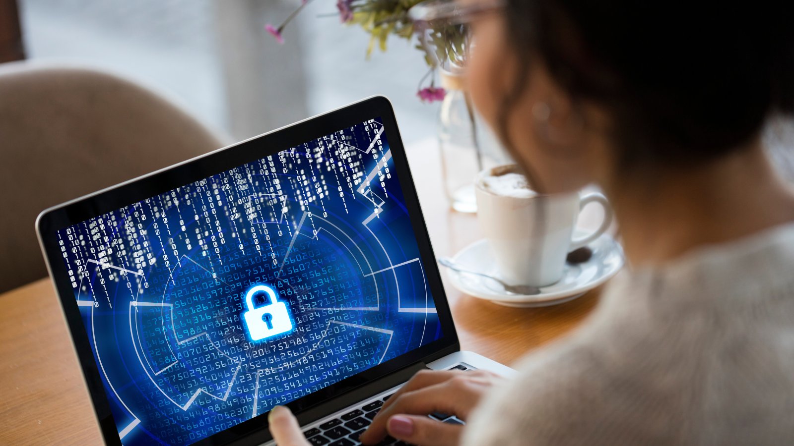 Person using laptop with cybersecurity lock icon on screen